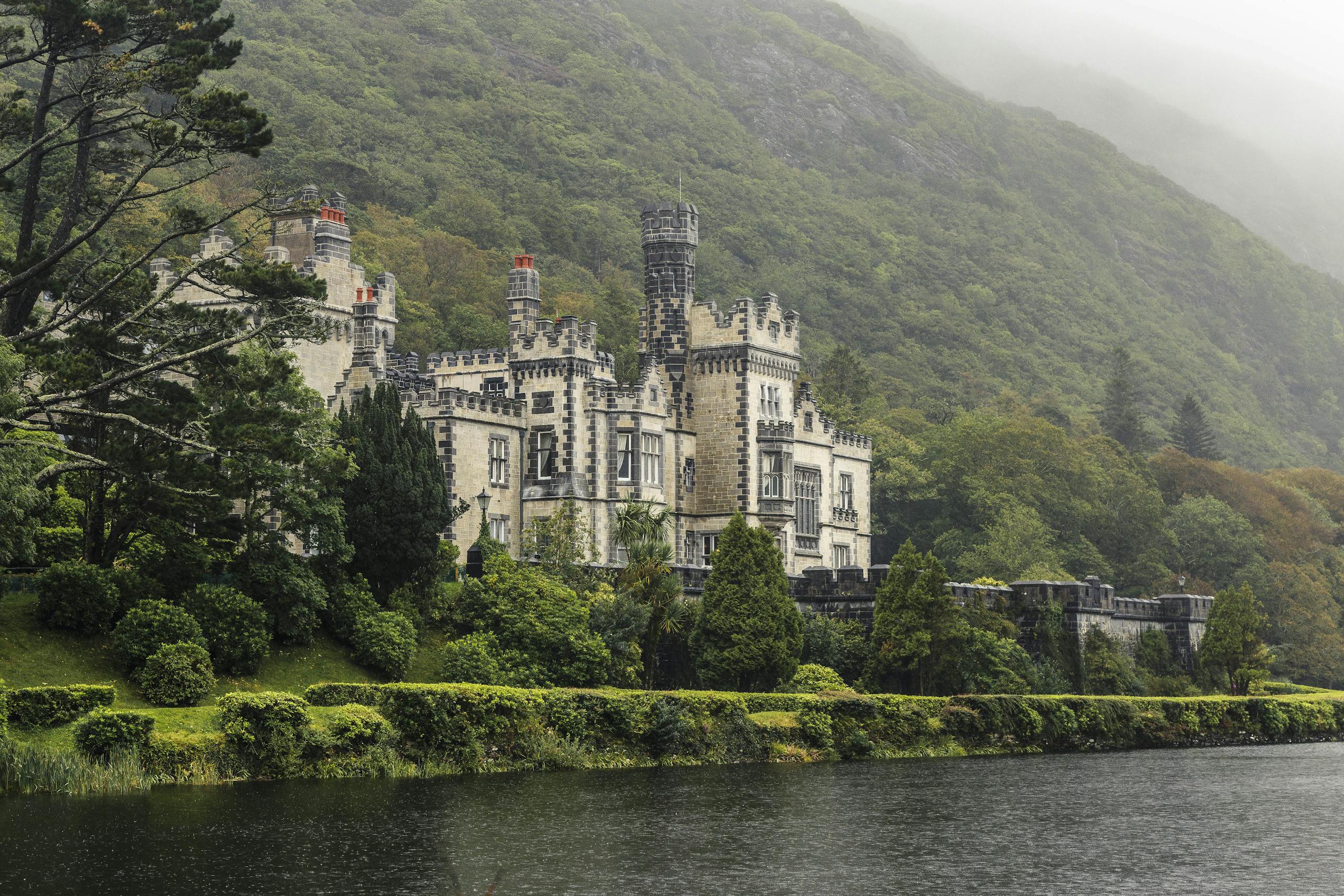 Beautiful view of Kylemore Abbey surrounded by lush greenery in Connemara, Ireland.